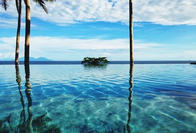 Swimming pool by sea against sky