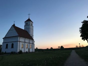 Church by building against sky during sunset