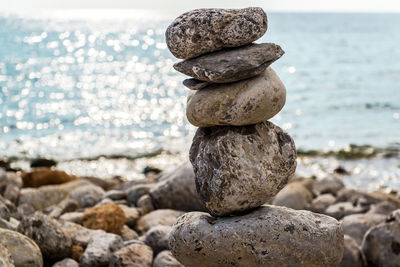 Close-up of stone stack on rock at sea shore