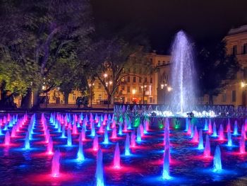 Illuminated fountain at night