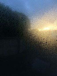 Full frame shot of wet window at sunset