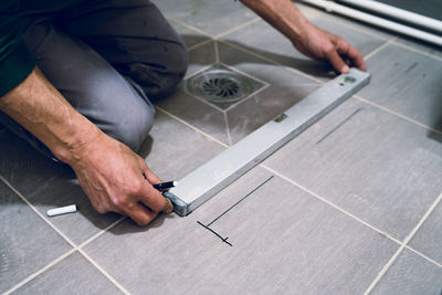 Midsection of man with spirit level working on floor