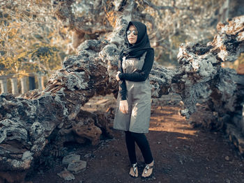 Full length of young woman wearing scarf and sunglasses standing on land