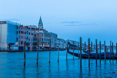 Boats in sea against buildings in city