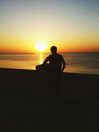 Silhouette of people on beach at sunset