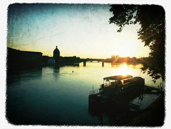 Boats in river at sunset