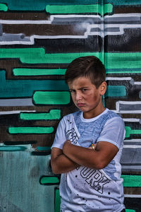 Portrait of angry boy standing against wall