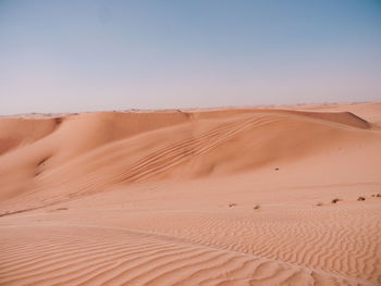 Sand dunes in desert against clear sky