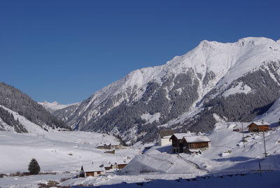 Scenic view of snowcapped mountains against clear blue sky