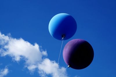 Low angle view of balloons against blue sky