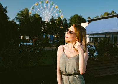 Young woman wearing sunglasses while standing outdoors