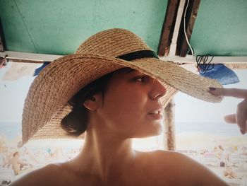 Shirtless woman wearing sun hat