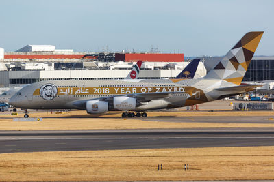 Airplane on airport runway against sky