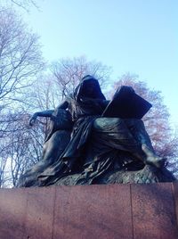 Low angle view of horse statue against trees