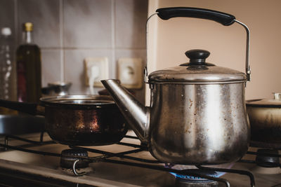 Close-up of kettle heating on burner in kitchen at home