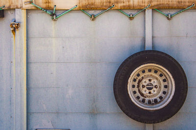 Close-up of tire track on tiled floor against wall