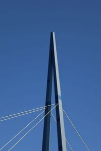 Low angle view of telephone pole against clear blue sky