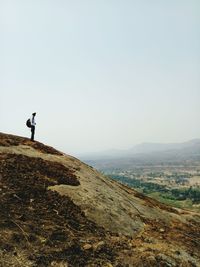 Man standing on mountain against clear sky