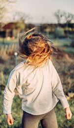 Rear view of woman standing on field