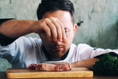 Close-up of male chef seasoning meat in kitchen