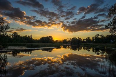 Reflection of clouds in lake against sky during sunset