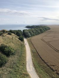 Scenic view of road by sea against sky