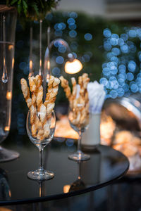 Close-up of sticks in wineglasses at table