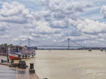 View of suspension bridge against cloudy sky