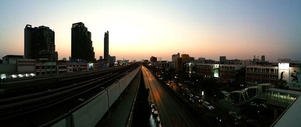 High angle view of illuminated city buildings against sky during sunset