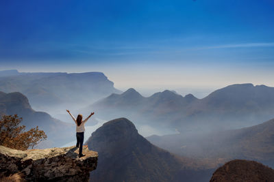 Carefree woman standing at cliff