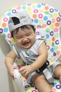 Cute baby boy sitting on sofa