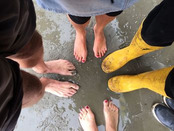 Low section of man and woman standing on mud