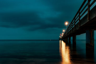 Illuminated sea against sky at night