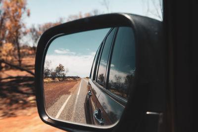 Reflection in side-view mirror of car