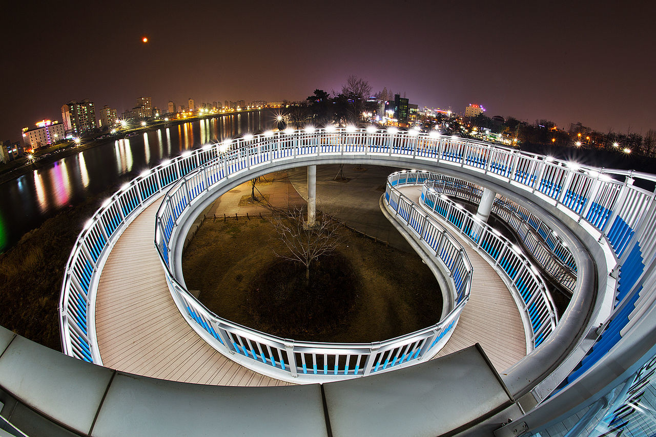 architecture, built structure, illuminated, night, building exterior, water, city, bridge - man made structure, connection, circle, river, arch, railing, travel destinations, modern, engineering, high angle view, clear sky, cityscape, famous place