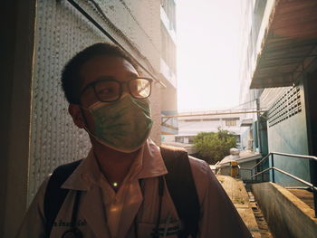 Portrait of teenage girl standing by window