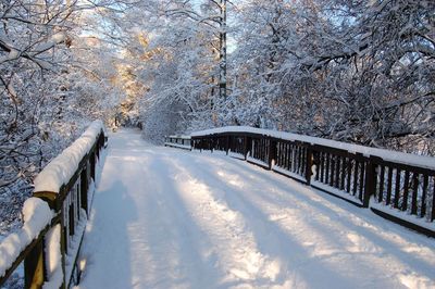 Snow covered footbridge against sky