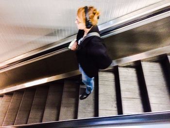 Full length of woman standing on escalator