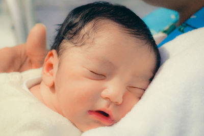 Close-up of baby sleeping on bed