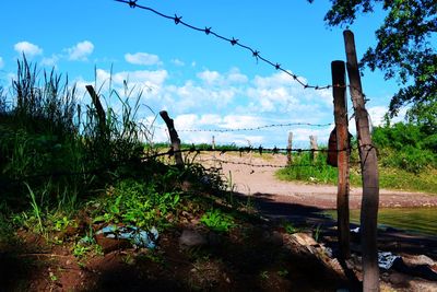 Fence on beach against sky