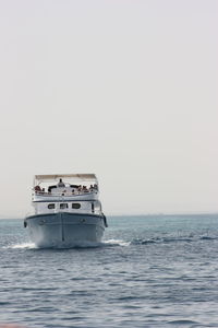 Ship sailing in sea against clear sky