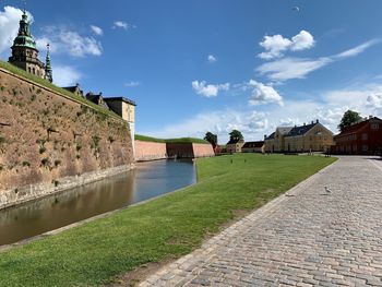 View of old building by river against sky