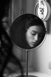 Close-up portrait of young woman looking a mirror