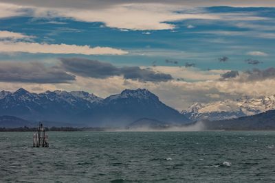 Scenic view of sea and snowcapped mountains against sky during sunset