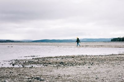 Man walking alone by the water and mountains in northern sweden