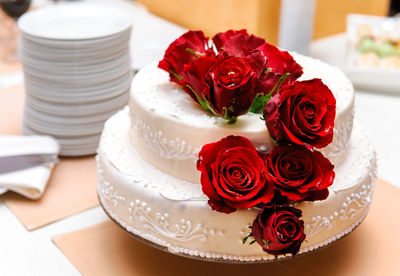Close-up of roses over cake on table