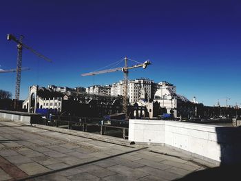 Crane at construction site against blue sky
