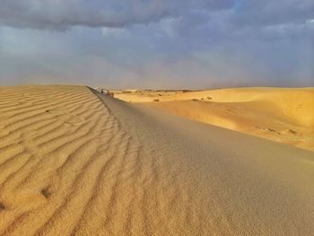 Sand dunes in desert with clouds sky before sandstorm