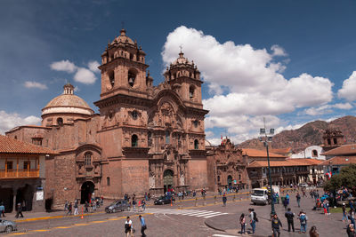 Group of people in front of historic building against sky