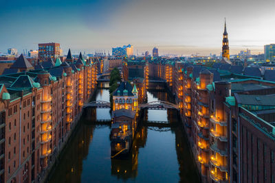 Illuminated buildings in city at waterfront